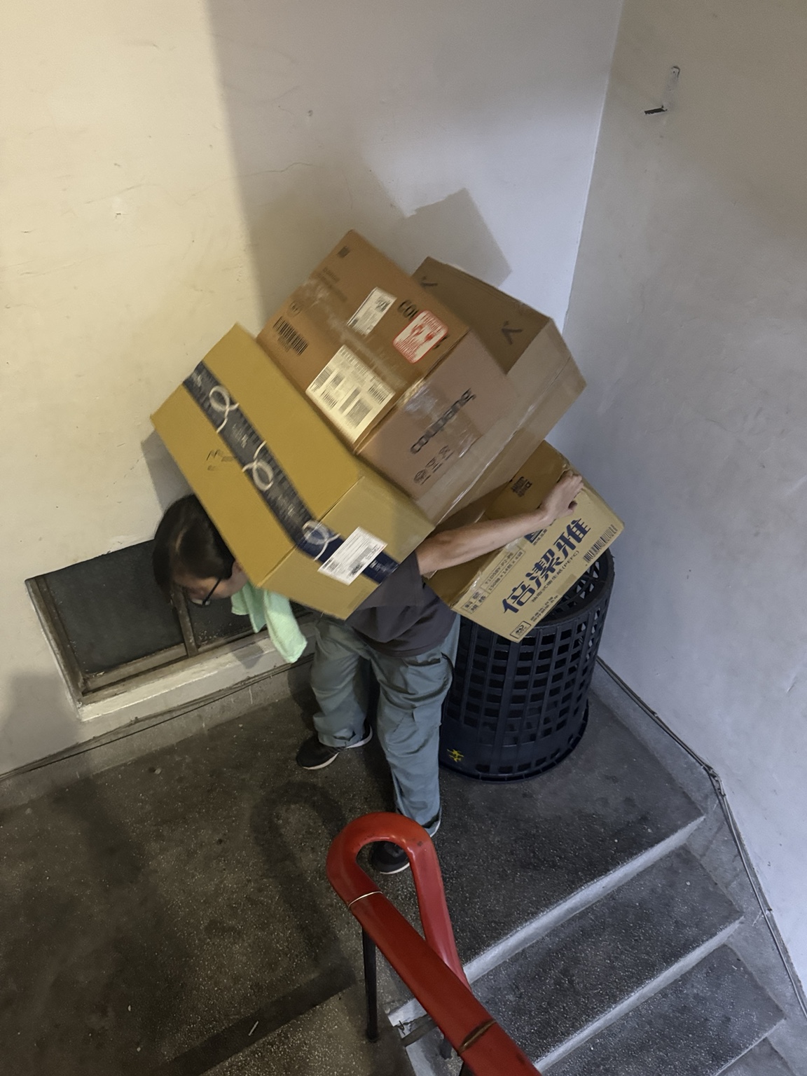 工作人員於樓梯間搬運多箱物品